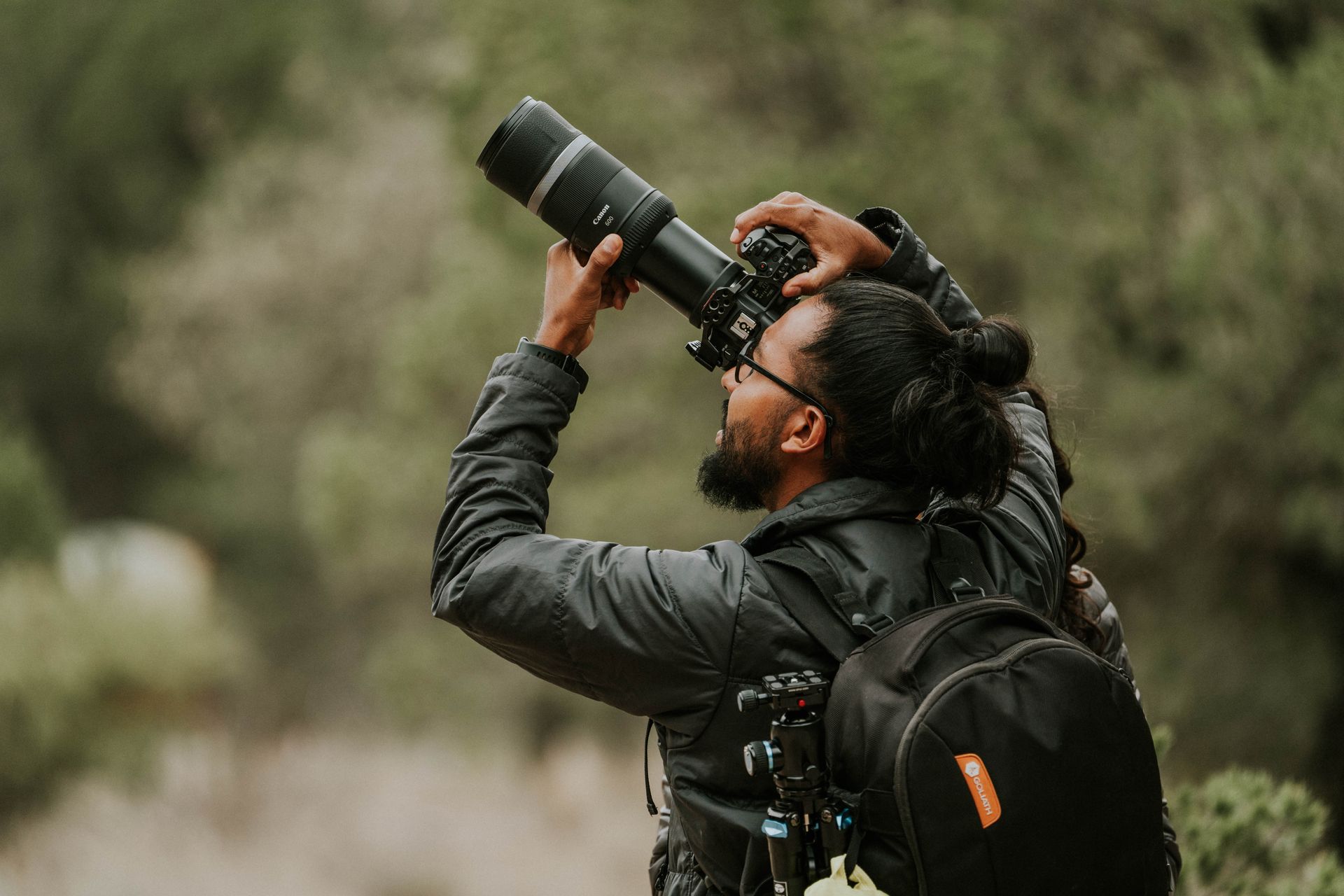 Photographe animalier à l’affût, téléobjectif pointé vers une falaise